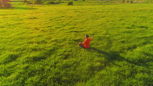 Low Altitude Radial Flight Over Sport Yoga Man at Perfect Green Grass