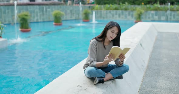 Woman read on the book and sit outside