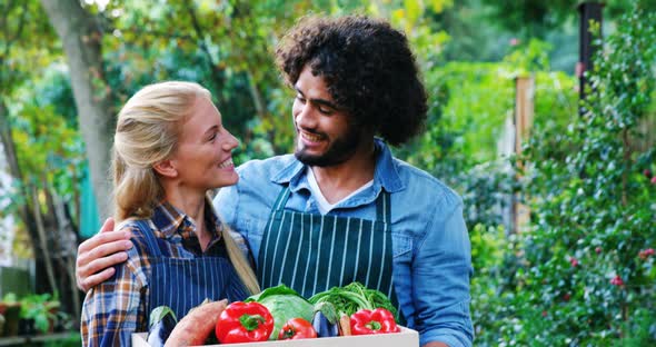 Gardener holding crate of fresh vegetables