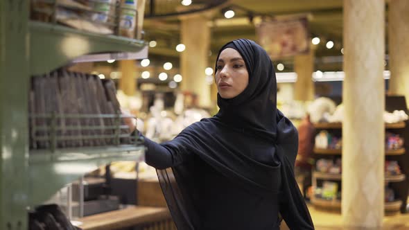 Woman in Hijab Takes Pile of Products From the Shelf in the Supermarket Slow Motion