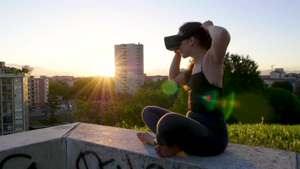 Slow motion shot of young woman using cyber glasses during sunset