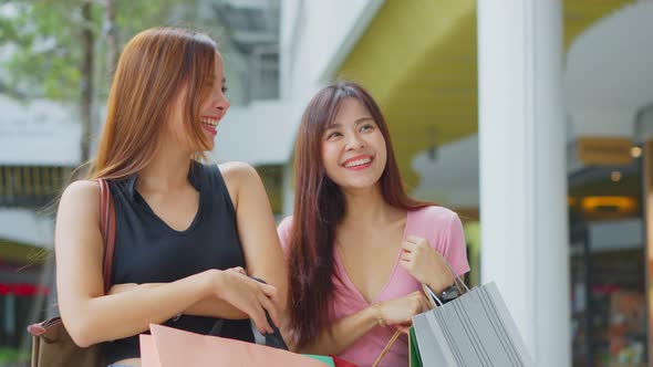 Asian young women shopping outdoor in department store during sale season at end of the year.