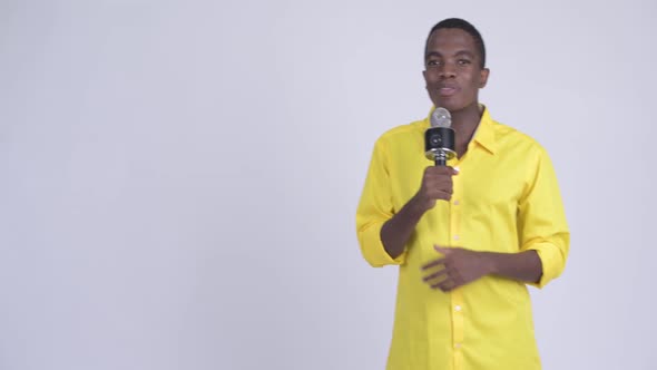 Young Happy African Businessman As Host Using Microphone