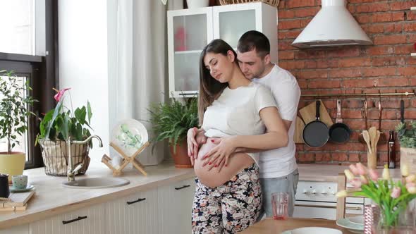 Pregnant Woman and Her Husband in Kitchen at Home