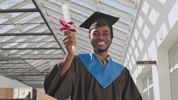 Portrait of Cheerful Male African-American Graduate in University