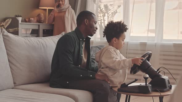 African American Father and Little Son Playing Race Video Game