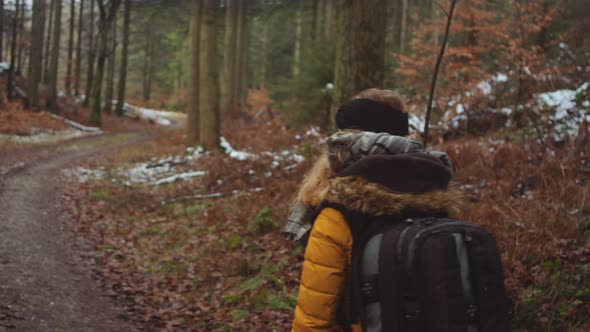 Teenage Girl With Rucksack Hiking Along Forest Path