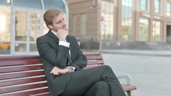 Tired Businessman Sleeping While Sitting Outdoor on Bench