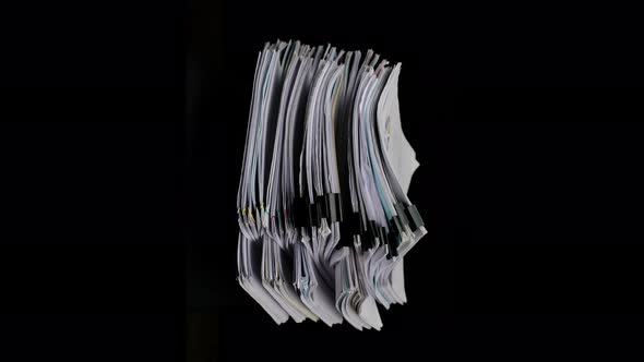 Stacks of business paper files turning on black background