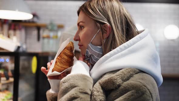 Woman in Protective Mask Makes Order in Cafe Sniffs a Croissant