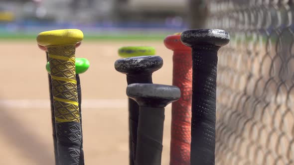 Details of bat handles at a little league baseball game.