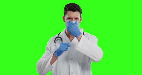 Caucasian male doctor wearing face mask on green screen background