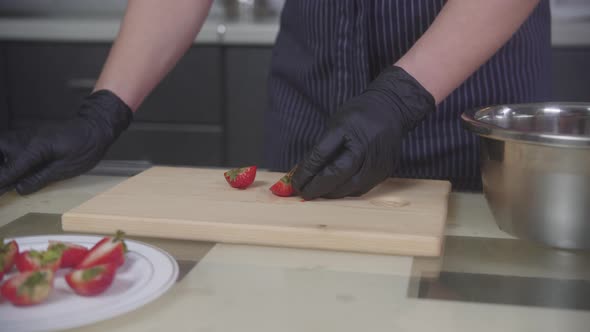 Confectionery  Pastry Chef Cuts Strawberries in Halves