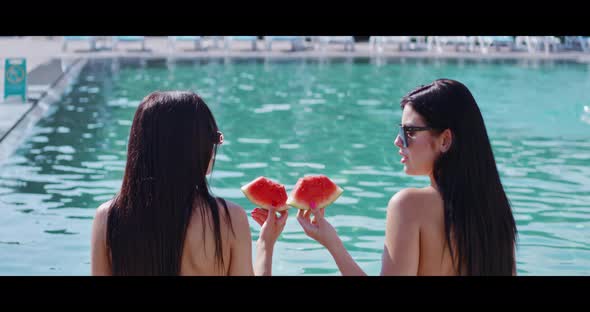 Gorgeous Women Enjoying Watermelon Near Outdoors Pool