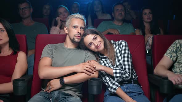 Happy Couple Hugging Watching Interesting Film at Cinema Full of Spectators Sitting on Armchair Row