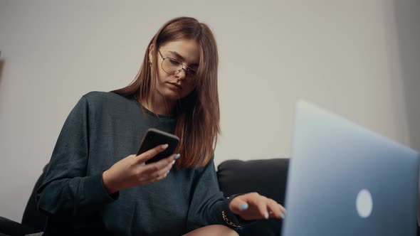 The Young Redhead Entrepreneur Works at Home on Laptop Receives a Call She Answers and Discusses the