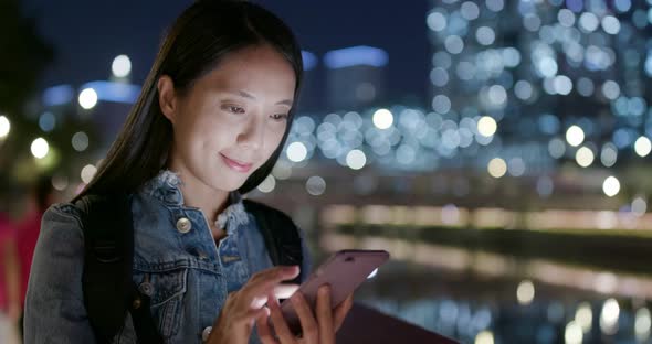 Woman use of mobile phone in city at night