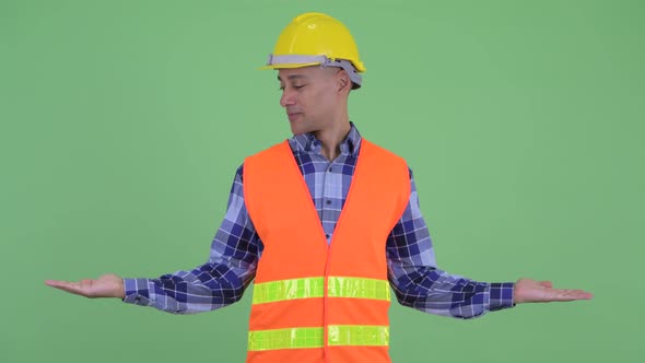 Happy Multi Ethnic Man Construction Worker Comparing Something
