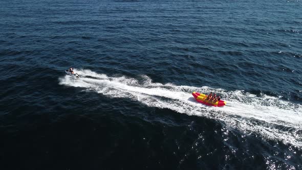 Happy People Swim on Air Mattress Behind a High Speed Water Bike