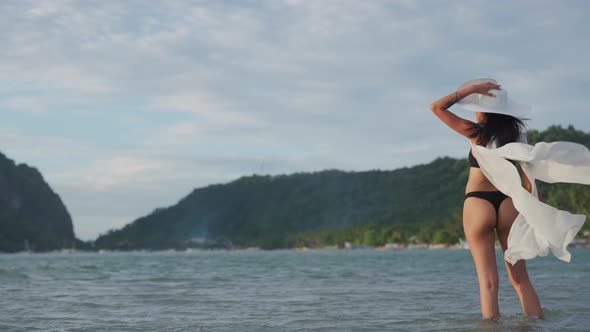 Young Woman In Thong And Sun Hat In Sea