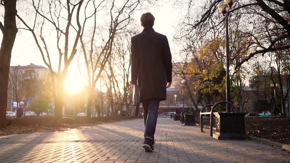 Serious Handsome Business Man Walks After Work in the Sunset Light of the City.