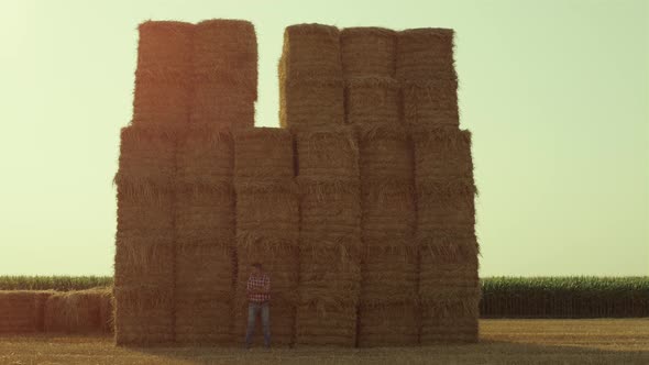 Farmer Resting Hay Bales on Sunny Day