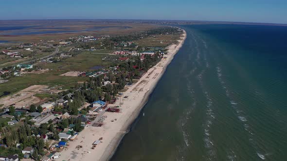 Beautiful flight in summer over the beach. People are resting near the sea.