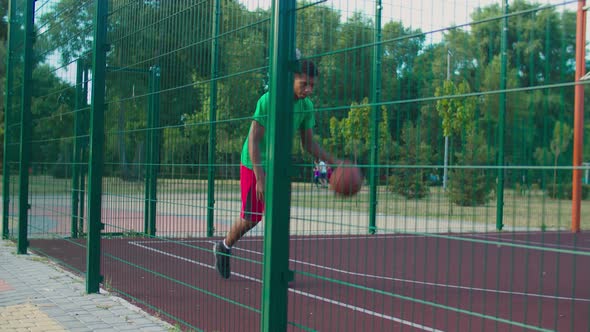 Serious Streetball Player Dribbling Ball on Court