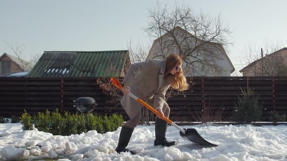 Woman Cleans Snow With Shovel