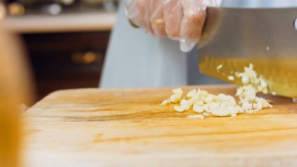 The Cook Crushes and Then Grinds the Garlic with a Professional Knife