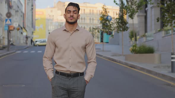 Serious Hispanic Arabic Businessman Walking in Formal Clothing Near Modern Building Background