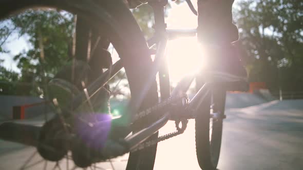 Close Up Shot of Young Man Riding BMX Bike in Extreme Park and Doing Tricks