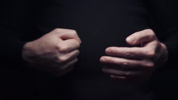 Close-up Man Beats His Fist in the Palm, Isolate on Black Background