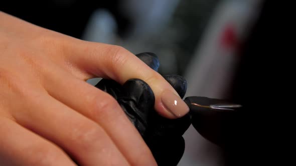 Experienced Manicurist Applies Layer of Gel on Fingernail