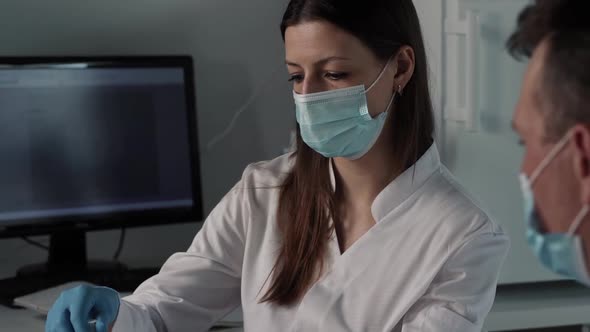 Female Doctor with Medical Mask and Gloves Prepares Prefilled Syringe for Injection By Removing Cap