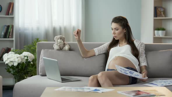 Woman Pregnant With Child Working on Laptop, Holding Graphs, Successful Career