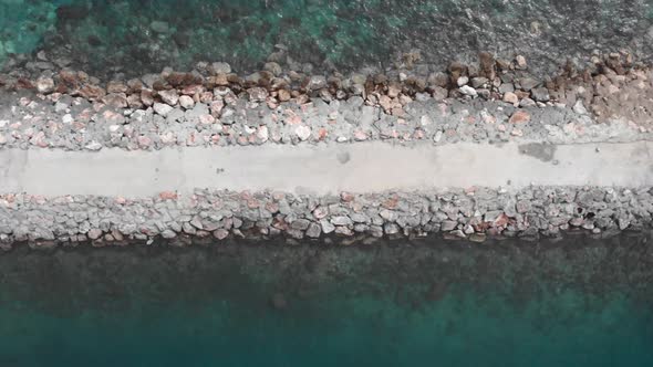 Coast with huge limestone rocks near pier and turquoise clear sea water