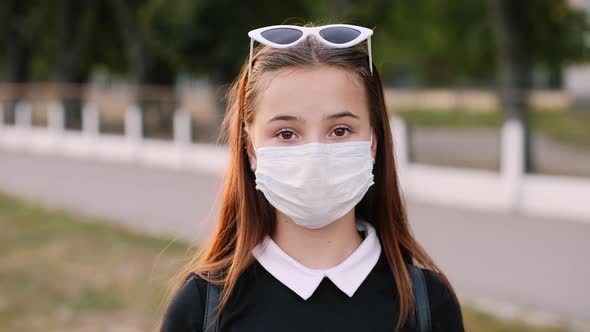 Portrait of Teenage Girl Wearing Medical Mask in City Park