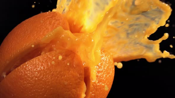 Fresh Orange Fruit Squirting with Juice in Slow Motion in Black Background