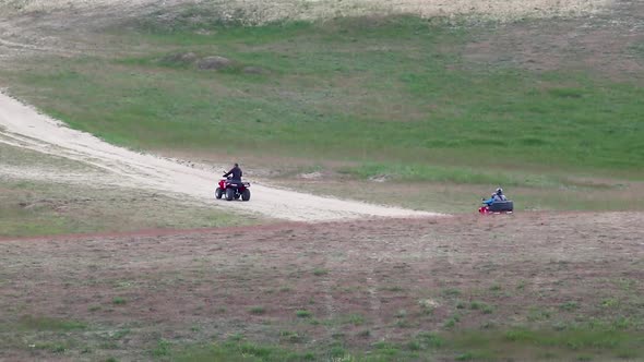 People Riding Quadbikes in spring off-road fields