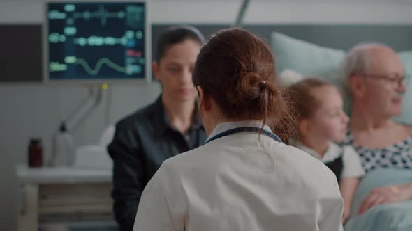 Close Up of Doctor Showing x Ray Scan to Daughter of Patient in Hospital Ward