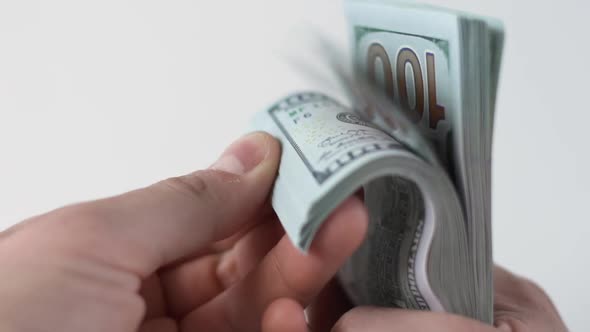 Man Counts Stack of 100 American Dollars Money