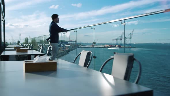 Pensive Man Resting Alone on Glass Restaurant Terrace