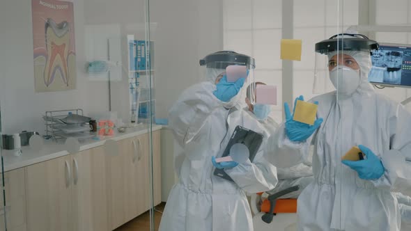 Dentistry Team of Specialists Using Sticky Notes on Glass