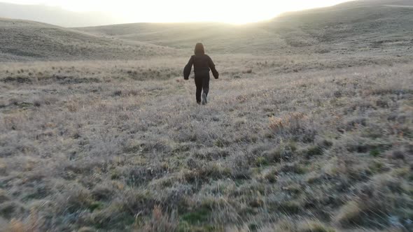 Boy Runs Down the Hill Against Sunset