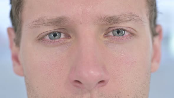 Close Up of Blinking Eyes of Young Male Looking at the Camera 