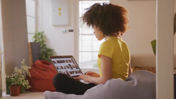 Mixed race woman working on computer in creative office