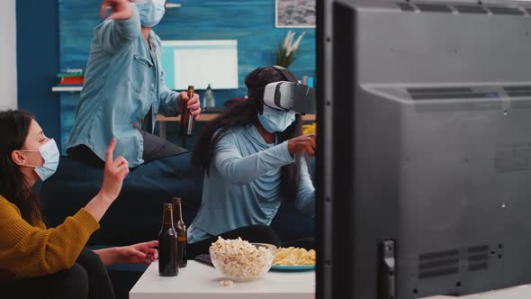 People with Face Masks Supporting African Friend Playing Video Games with Vr Headset