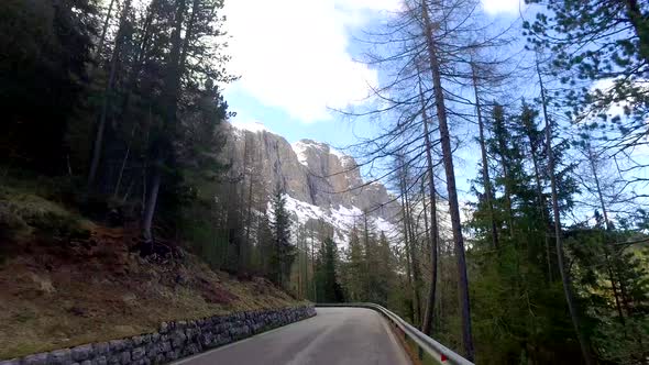 View from a driving car on the winding roads in the mountains, Dolomites, Alps