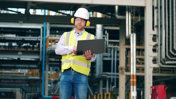 Engineer is Using Gadgets for Communication at the Oil Refinery